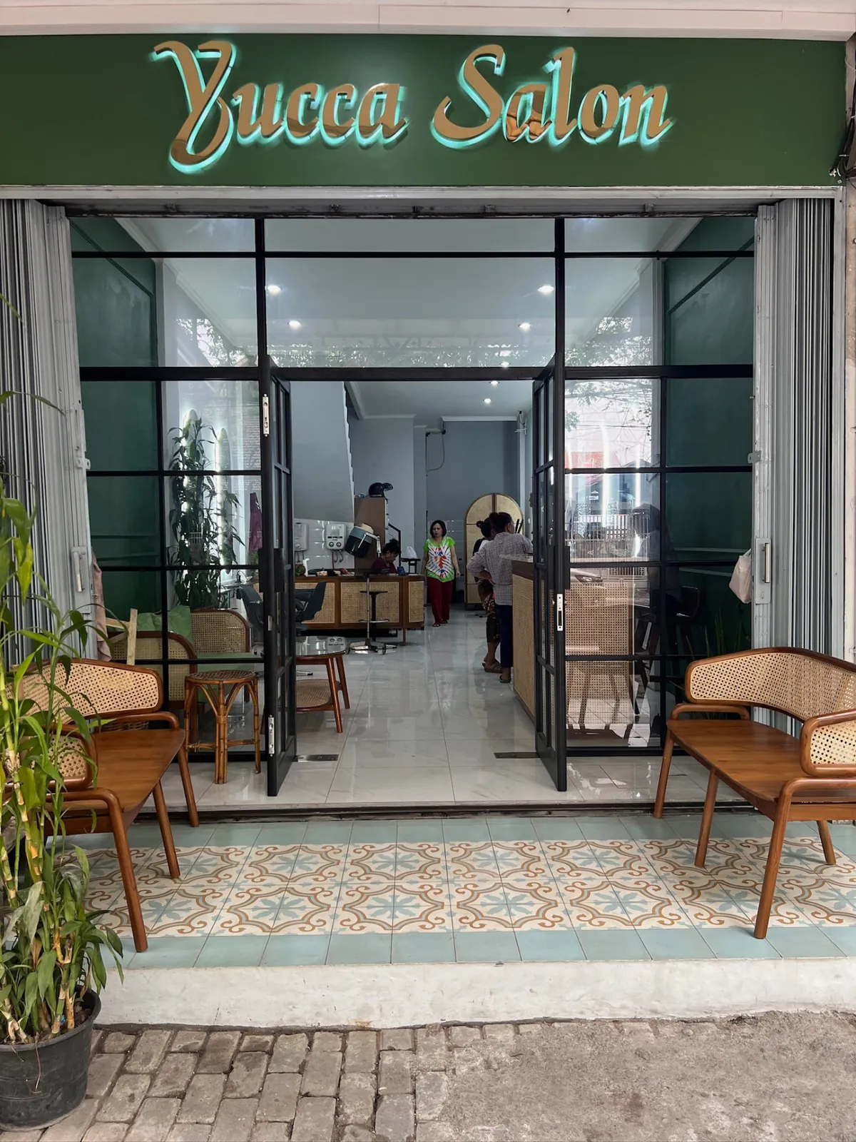Tampak depan Yucca Salon berwarna hijau di Jl. Gandapura, Sumur Bandung, dengan kursi rotan di teras